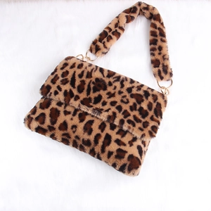 Detail of plush leopard print shoulder bag featuring large golden metal rings and soft faux fur