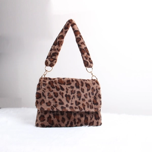 Detail of leopard print faux fur shoulder bag with soft plush texture and golden metal rings