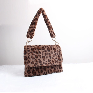 Detail of leopard print faux fur shoulder bag with soft texture and golden metal rings
