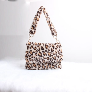Detail of leopard print plush handbag showing soft faux fur texture and gold metal rings
