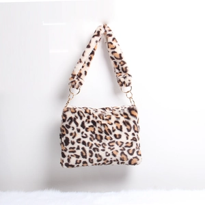 Detail view of leopard print plush handbag with soft faux fur texture and gold chain