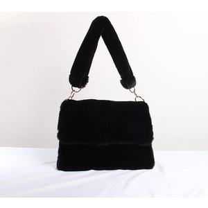 Detail of a fluffy black faux fur handbag with a thick shoulder strap and gold hardware