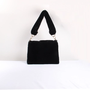 Detailed view of plush black faux fur shoulder bag with gold metal ring connectors