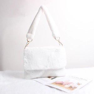Detail of white plush shoulder bag featuring soft faux fur texture and golden metal rings