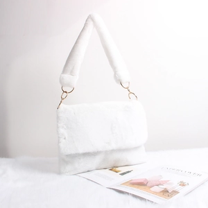 Detail of white faux fur shoulder bag featuring soft texture and gold metal rings
