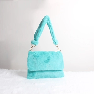 Detail of mint green plush shoulder bag with thick faux fur strap and metal rings