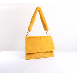 Detail of yellow plush faux fur shoulder bag with golden metal rings and wide strap