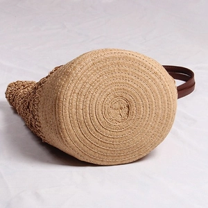 Handmade woven straw bucket bag with floral hollow design and leather handles for beach