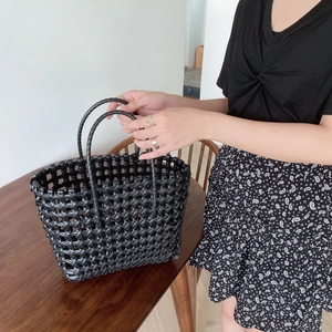 Handcrafted black hollow-out woven tote bag with round handles for beach or casual travel