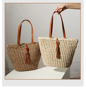 Close-up of woven straw tote bags with leather handles and tassel detail in coffee and beige