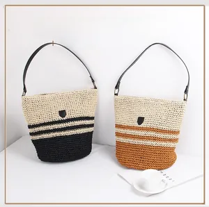Detail of striped straw bucket bags with leather handles for summer beach vacations