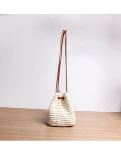 Detailed close-up of handmade woven bucket bag featuring brown faux leather drawstrings