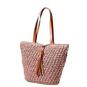 Handmade straw tote bag with leather handles and tassel pendant for beach vacations