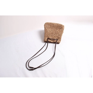 Top view of woven straw bucket bag showing diamond texture and dark brown straps