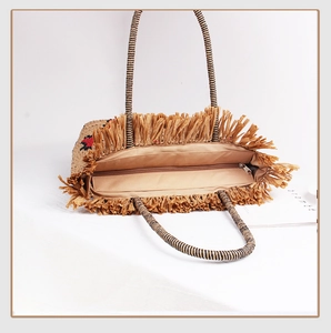 Detailed view of straw handbag with leopard print straps, inner lining, and zipper closure
