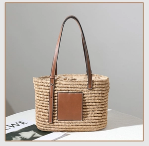 Detail of hand-woven square straw bag with brown leather handles and interior lining
