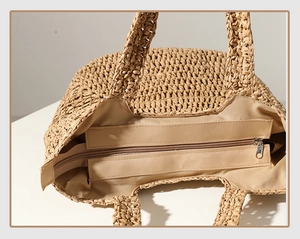 Detailed view of the woven straw tote bag with a secure zipper closure and fabric lining