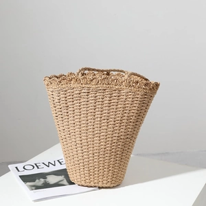 Handmade woven straw bucket bag with scalloped edges for summer beach vacations