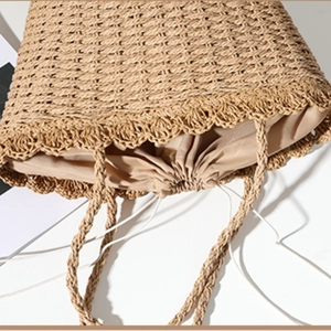 Handwoven straw tote bag with drawstring closure and top handle for beach vacations