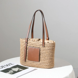 Square woven straw tote bag with brown leather patch and drawstring lining for summer beach