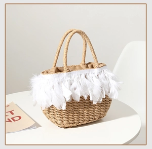 Close-up of handmade straw bag with fluffy white feathers and woven texture