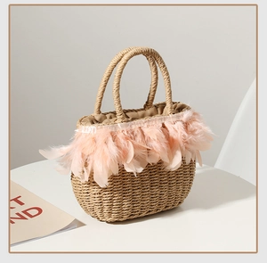 Detailed straw woven handbag featuring soft pink feather trim and durable woven handles