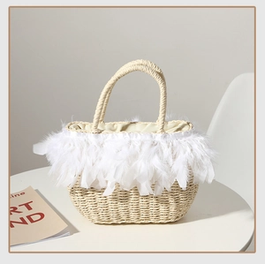 Close-up of beige woven straw tote bag with elegant white feather trim and lining detail