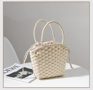 Detail of cream straw woven handbag with drawstring liner and textured braided handles