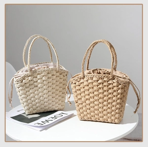 Detail of straw woven handbags with drawstring lining shown from a top-down angle