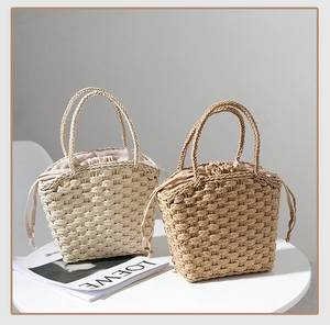 Detailed close-up of handmade straw tote bags with woven texture and drawstring lining