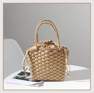 Detailed view of hand-woven straw tote bag with inner drawstring pouch and textured handle
