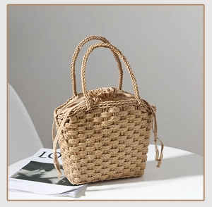 Detail of straw woven handbag featuring natural fiber texture and beige drawstring liner