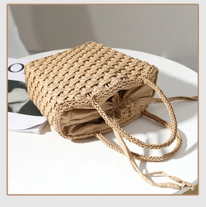 Detail of hand-woven straw bag featuring natural plant fibers and drawstring inner pouch