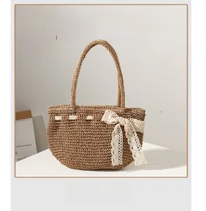 Détail du sac à main en paille tressée à la main avec un nœud en dentelle blanche