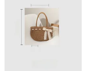 Détail du sac de plage en paille avec nœud en dentelle blanche et dimensions 35x18cm