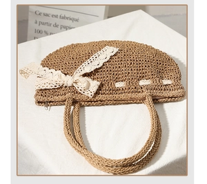 Détail du sac en paille tissé à la main avec un nœud en dentelle et texture naturelle
