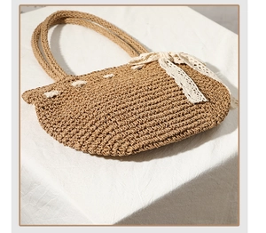 Vue détaillée de la texture d'un sac en paille avec un nœud décoratif en dentelle crème