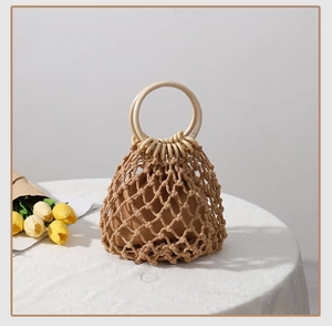 Detail der handgewebten Netztasche mit Holzgriffen und Baumwollfutter auf Spitzendecke