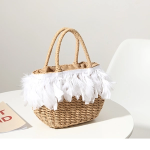 Handmade straw handbag with white feather fringe details and top handles for vacation