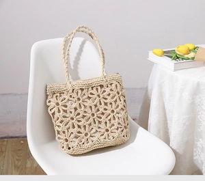Detail of hollow floral pattern on a straw beach bag with secure zipper closure