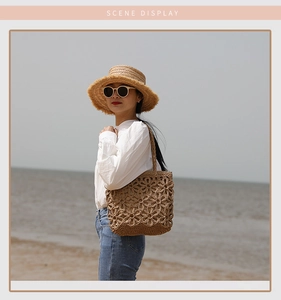 Detail of straw tote bag with hollow floral pattern and matching sun hat for beach vacation