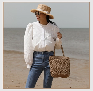 Close-up of hollow floral knit patterns on a woven straw tote bag for beach vacations
