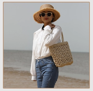 Close-up of hollow crochet straw tote bag with large floral accents for beach vacations