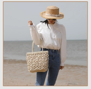 Detail of straw woven bag featuring hollow floral pattern for seaside beach vacations