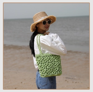 Detailed close-up of green crochet floral tote bag with beach vacation background