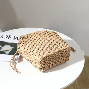 Minimalist straw woven handbag with drawstring closure for beach and vacation style