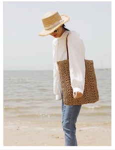 Detailed texture of dark brown hand-woven straw tote bag for summer beach holidays