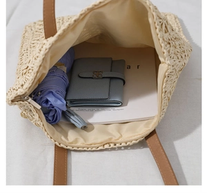 Top view of spacious straw tote bag showing internal storage with umbrella and wallet