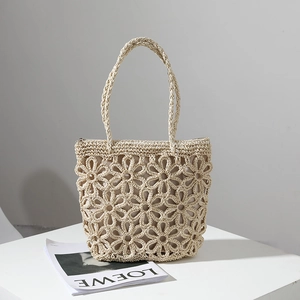 Handcrafted beige straw tote bag with hollow floral crochet patterns for beach vacations