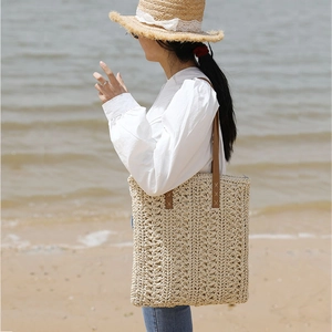 Large cream straw tote bag with brown leather straps for beach holidays and summer travel
